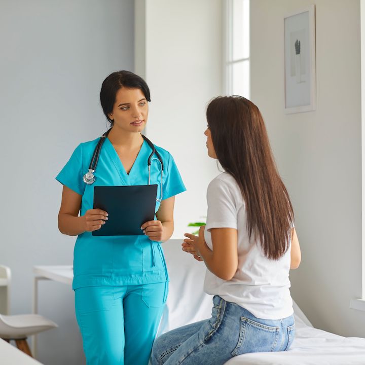 A female physiotherapist discussing with a female patient about something related to mental health.