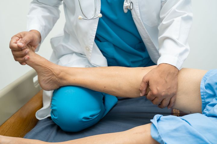 A physiotherapist administering massage on a patient's leg (faces not shown).
