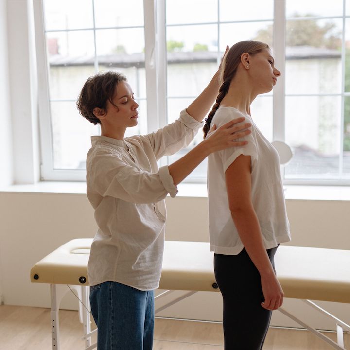 A physical therapy checking the posture of a patient.