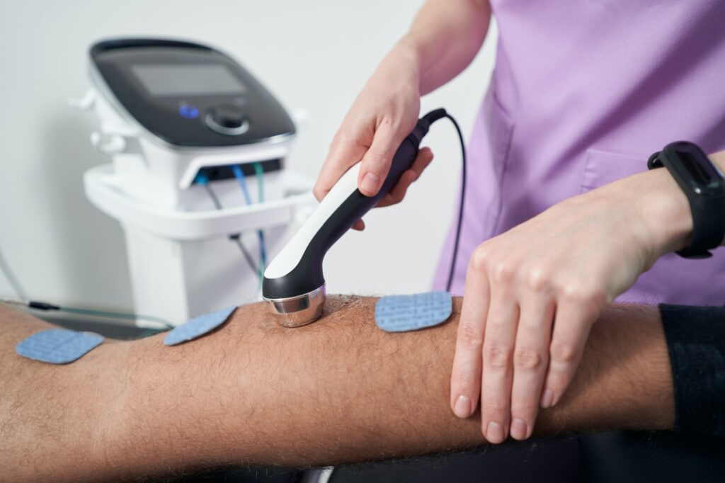 Man having ultrasound therapy procedure in physical therapy clinic