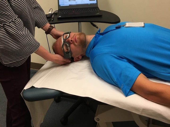 Occupational therapy grad student Marcus Thune helps Sanford physical therapist Jayme Watson demonstrate the use of the ICS Impulse goggles. Watson uses the goggles to help treat vertigo.