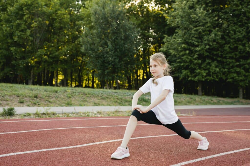 Child girl stretching before running