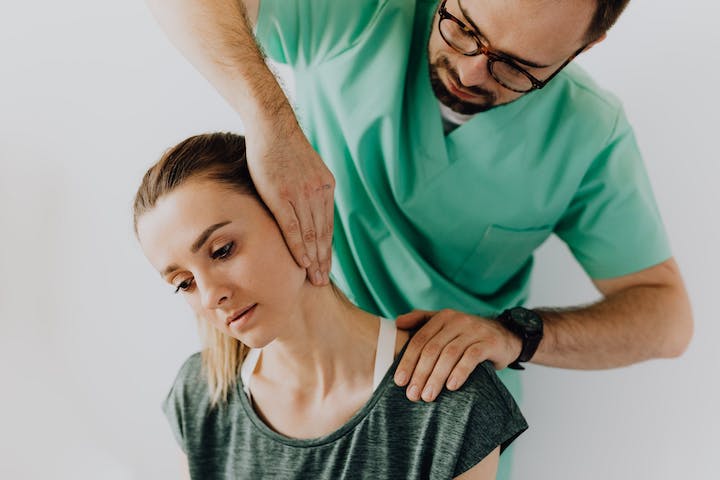 A physiotherapist checking up on a patient's neck.