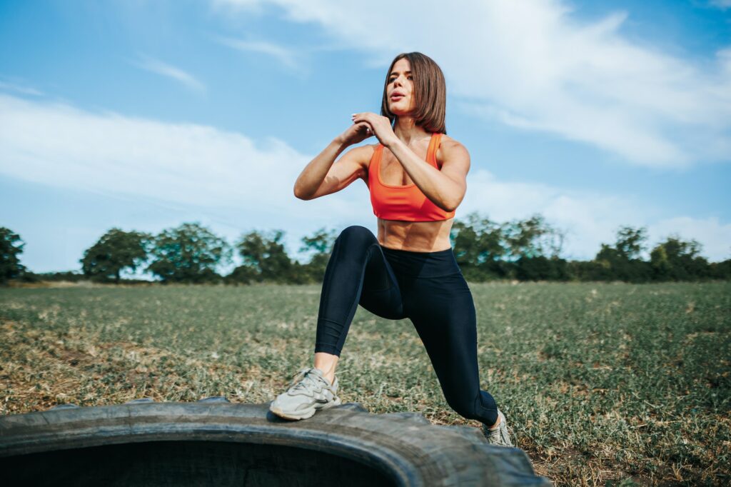 Physical Exercise with Tire Fit Woman's Intense Crossfit Session Outdoors