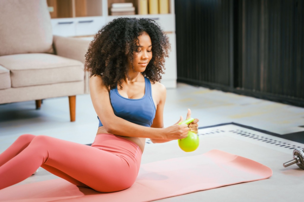 A woman performs advanced kettlebell exercises for strength and mobility during her workout session.