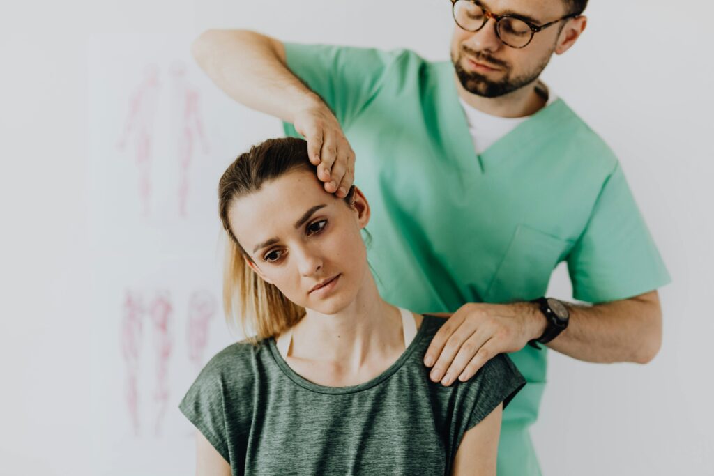 A man receives a neck examination from a chiropractor in a professional office environment.