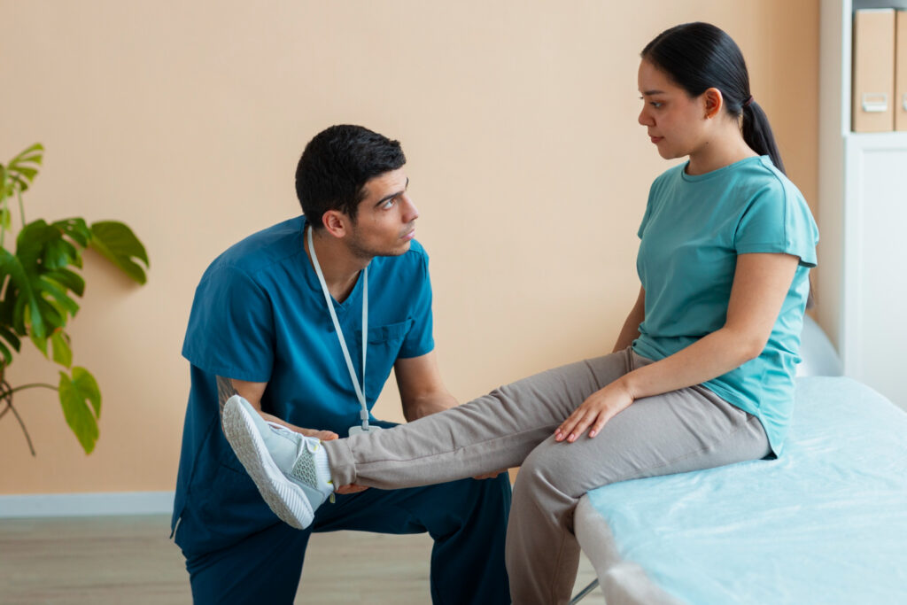 A woman discusses her health with a male doctor while seated on a bed, focusing on podiatry and physiotherapy.
