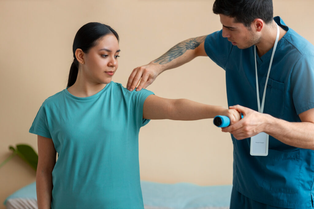 A man participates in physical therapy with a woman, focusing on treatment for shoulder bursitis.