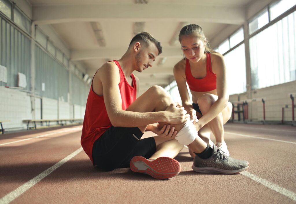 A man and woman sit on the floor, both with leg braces, reflecting on how their mobility challenges affect daily life.