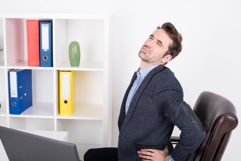  A man at his desk, facing away, highlighting the importance of good posture to prevent chest pain.