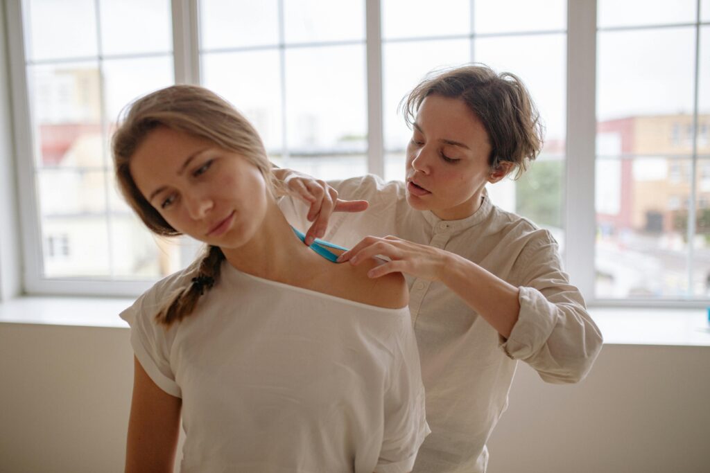 A woman gently brushes another woman's hair, promoting relaxation and preventing shoulder bursitis through gentle movements.