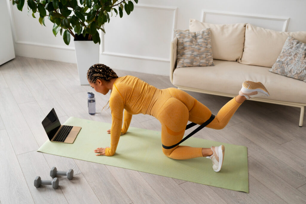 A woman dressed in yellow does a push-up on a yoga mat, emphasizing the importance of gluteus medius strength.