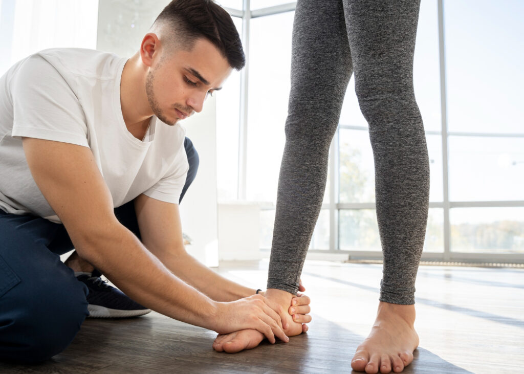 A man assists a woman in putting on her shoes, highlighting support in managing heel fat pad syndrome through exercises.