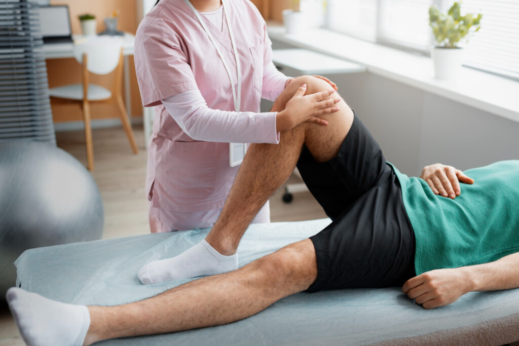 A man receives a knee examination from a physical therapist, highlighting the importance of physiotherapy in recovery.