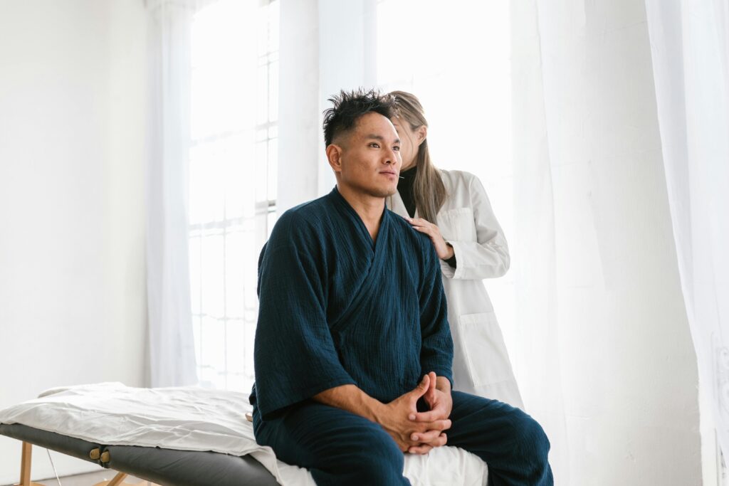 A man and woman sit together on a bed, discussing the timeline for noticing improvement with dry needling therapy.