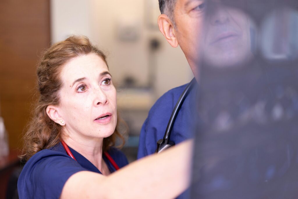 A woman and a man in a hospital room exploring treatment options for chest pain linked to posture issues.