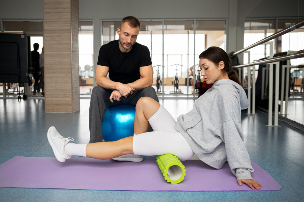  A man and woman sit on a mat, engaged in a workout, demonstrating focus and determination in their exercise routine.