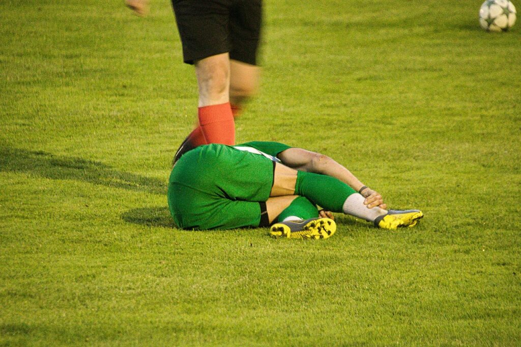 A soccer player lies on the ground, showcasing a moment of exhaustion during a match, with Keep Shoes From Slipping Off 