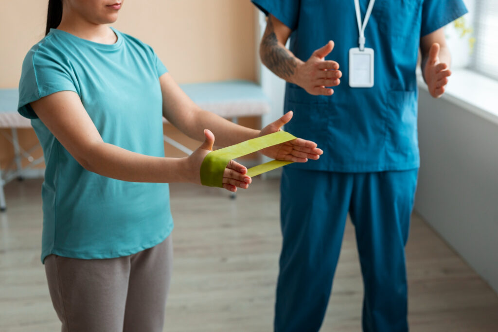 A woman and a man stand together in a room, focusing on wrist strengthening exercises in an Australian setting.