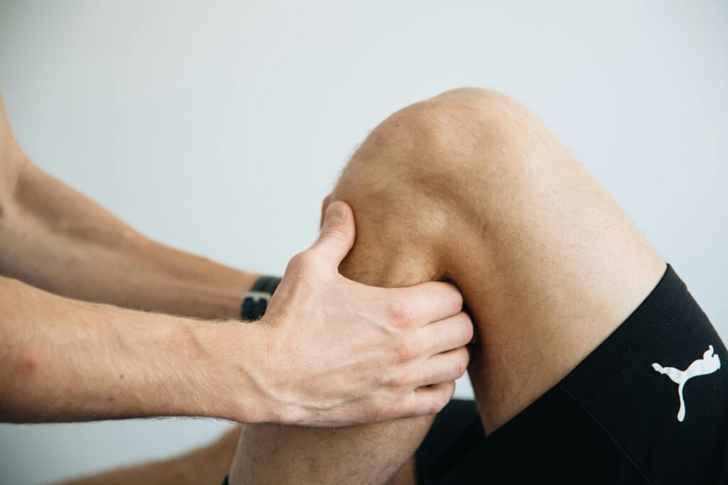 A doctor massages a man's knee, highlighting the benefits of stretching for improved mobility and pain relief.