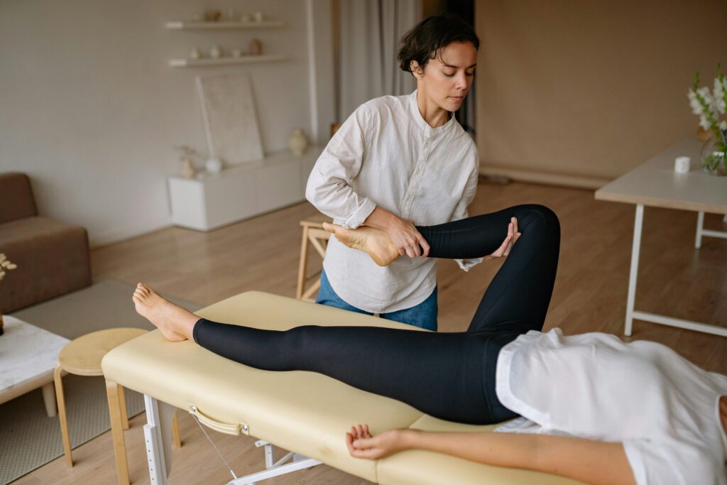 A woman receiving a massage focused on iliacus muscle release in a serene room setting.