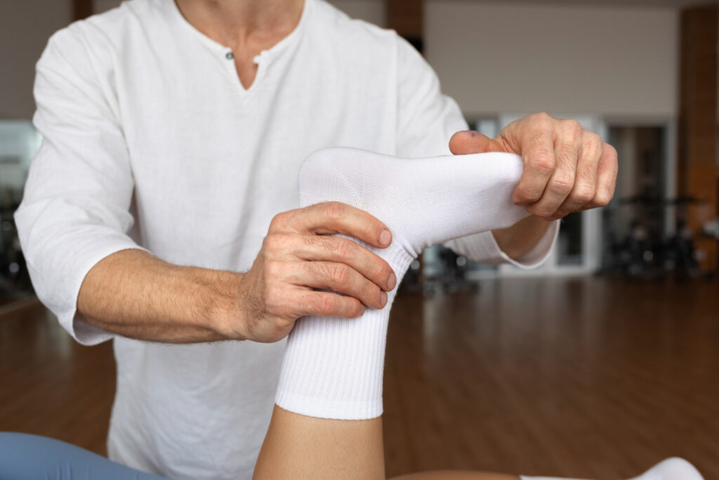 A man enjoys a foot massage from a physical therapist, focusing on gentle mobilization and stretching techniques.
