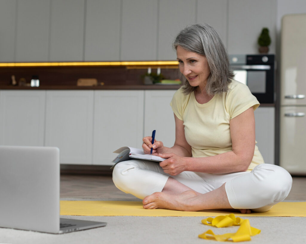 A woman sits on the floor with a laptop, emphasizing the value of professional guidance in her work or studies.