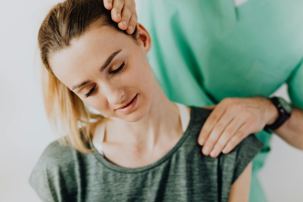  A woman receiving a neck examination from a chiropractor, focusing on initial self-care strategies for wellness.
