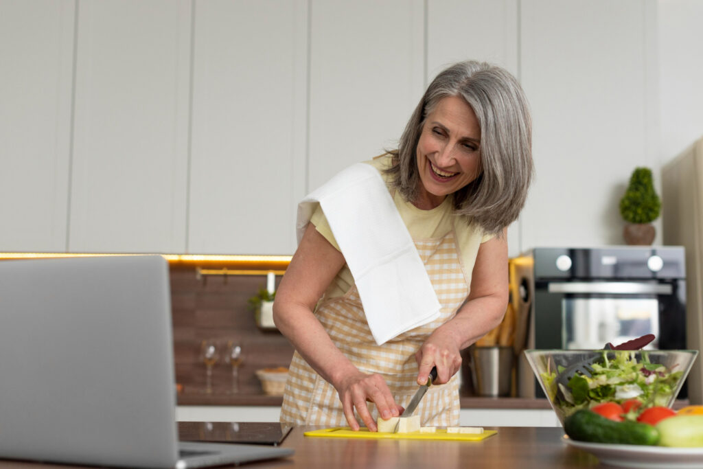 A woman skillfully chopping fresh vegetables in a bright kitchen, focusing on healthy meal prep for women over 60.