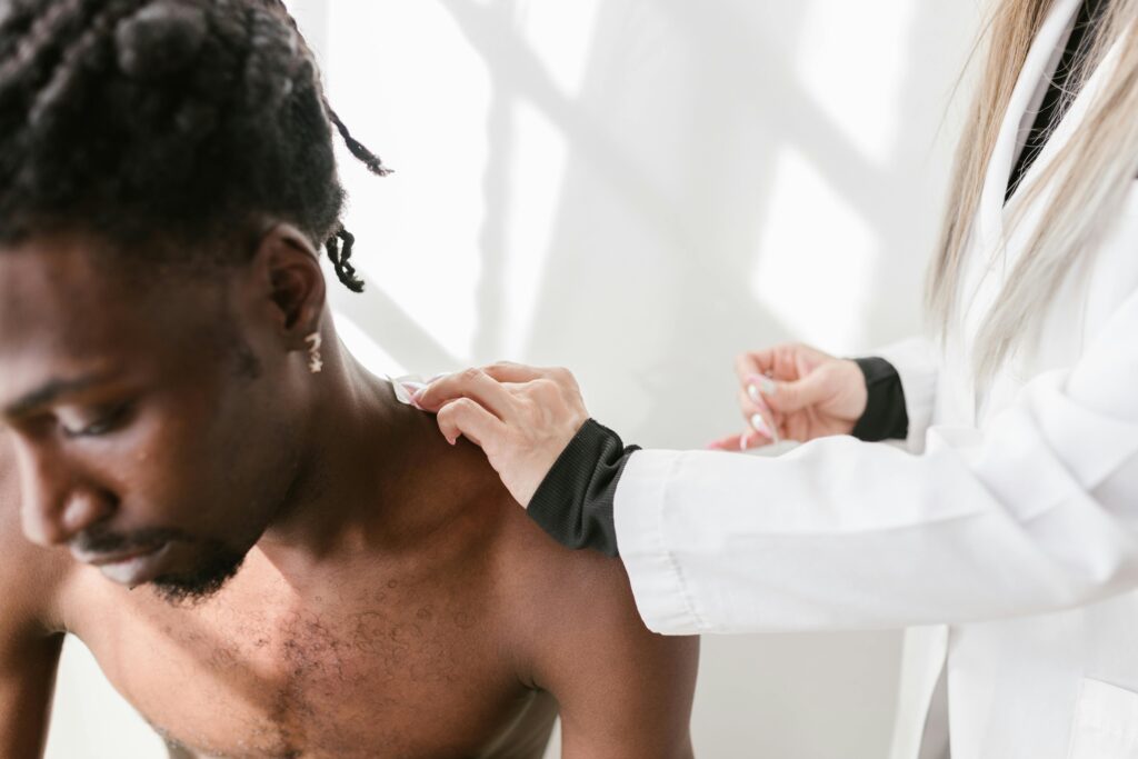 A doctor examines a man's chest during a physiotherapy session, focusing on health and wellness.