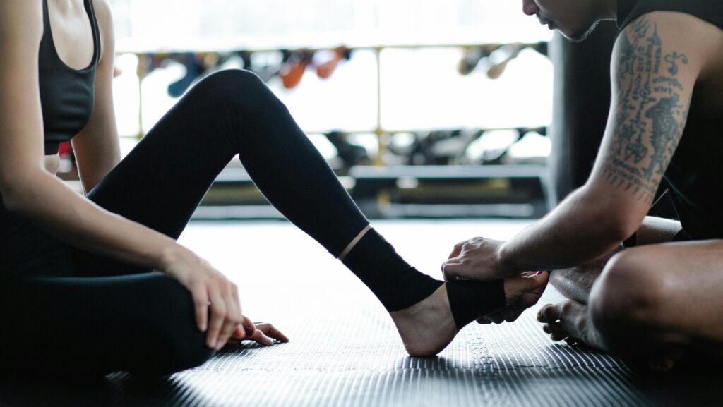 A woman secures her foot to a man's leg, symbolizing connection and support in prevention and treatment strategies.