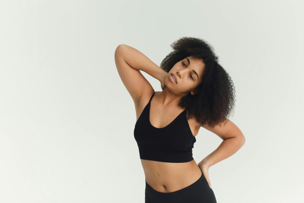 A woman wearing a black sports bra and leggings, demonstrating fitness and health awareness while recognizing symptoms.