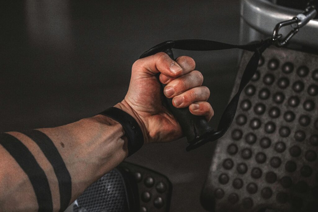 A man's hand grips a barbell, demonstrating proper form for safe wrist exercise techniques.