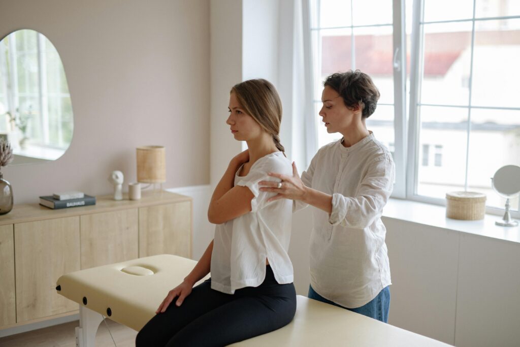 A woman enjoys a relaxing massage from a skilled therapist in a serene treatment setting.