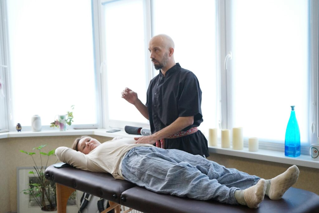  A man receiving a professional massage from another man in a serene treatment room.
