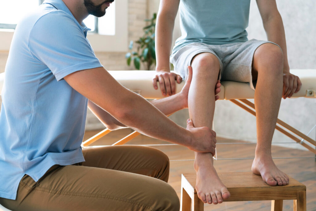 A doctor examines a man's leg, focusing on a Grade 1 calf strain during a routine check-up.