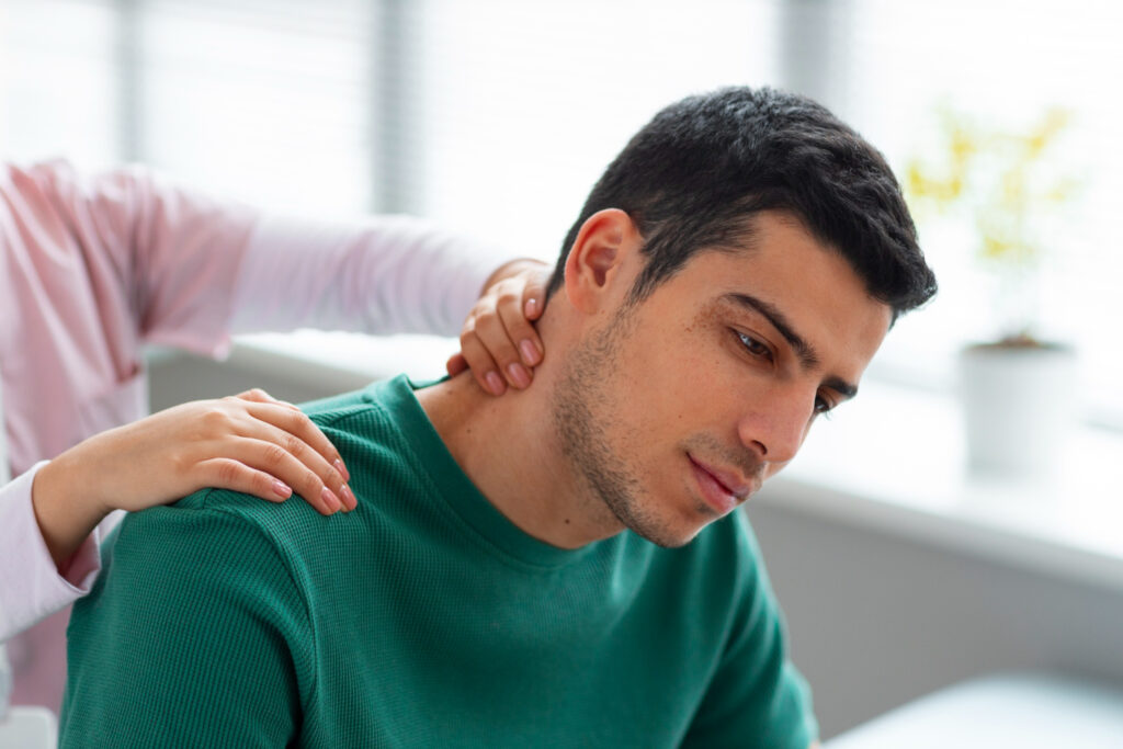 A man receiving therapy with pressure applied to acupressure points for neck pain and shoulder pain. The treatment focuses on relieving tension and improving mobility.