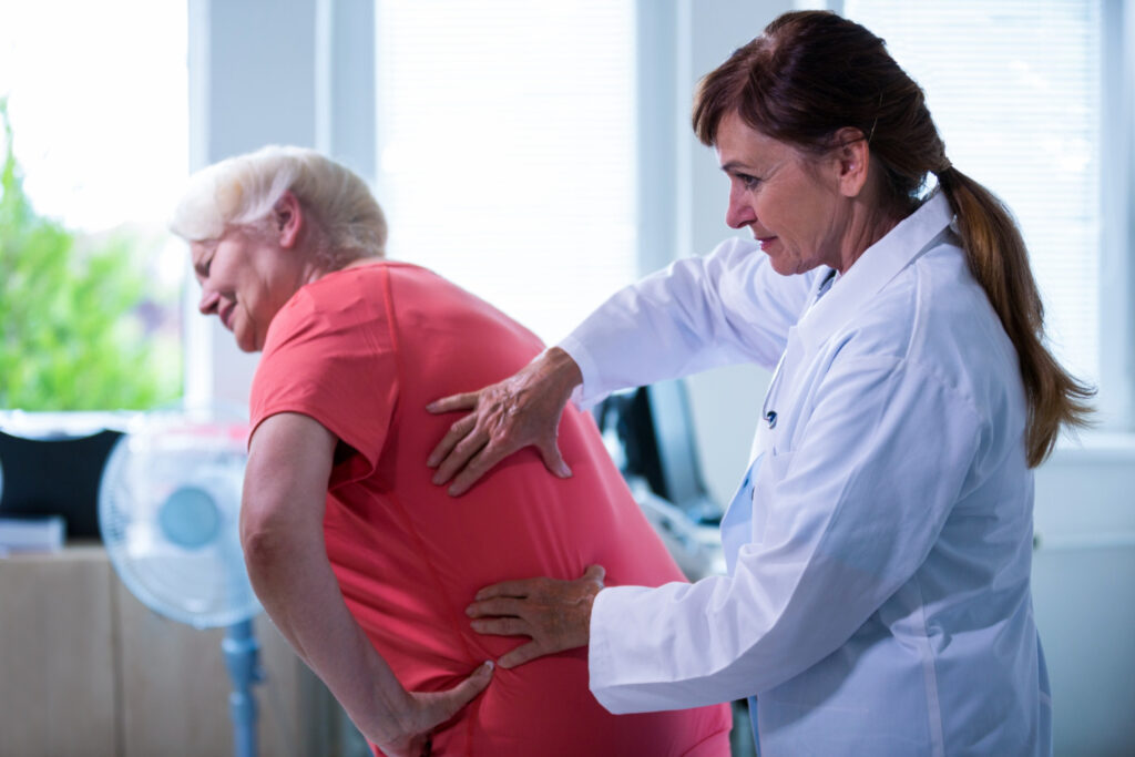  A woman consults a doctor for a back examination, highlighting the importance of seeking medical attention when needed.
