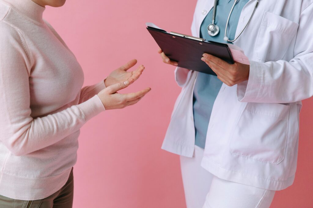 A female doctor attentively discusses health concerns with a patient, emphasizing the importance of seeking medical attention.